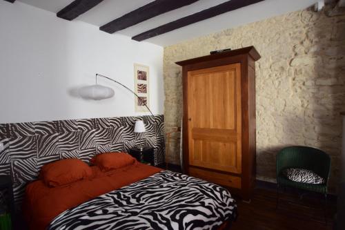 une chambre avec un lit à imprimé zèbre et une porte en bois dans l'établissement Atypique, à La Roche-Posay