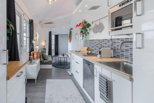 une cuisine avec des armoires blanches et un évier dans l'établissement La terrasse, vue sur les toits de Montpellier, à Montpellier