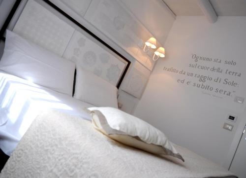 a bed with a pillow and a sign on the wall at Iblainsuite in Ragusa