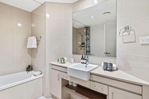 a white bathroom with a sink and a mirror at 116 Cairns One in Cairns