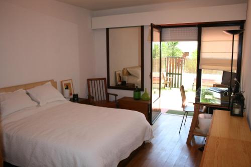 - une chambre avec un lit et une porte coulissante en verre dans l'établissement At the beach with a private garden, à Carcavelos