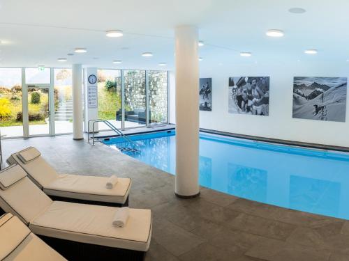 ein Schwimmbad in einem Gebäude mit Pool in der Unterkunft Hotel Hanauerlehen - ruhige & zentrale Top-Lage - mit Schwimmbad, Sauna, Parkplätze & Café - bayerischer Familienbetrieb in Schönau am Königssee
