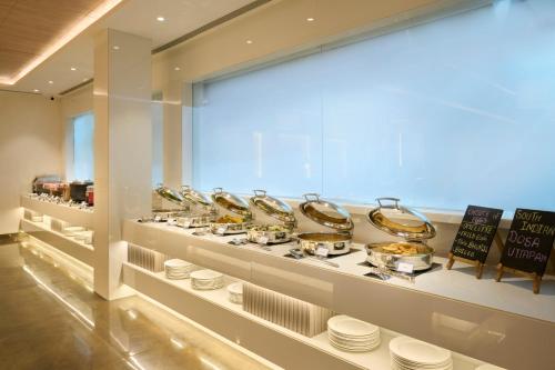 a display case in a store with bowls and plates at Delite Sarovar Portico Faridabad in Faridabad