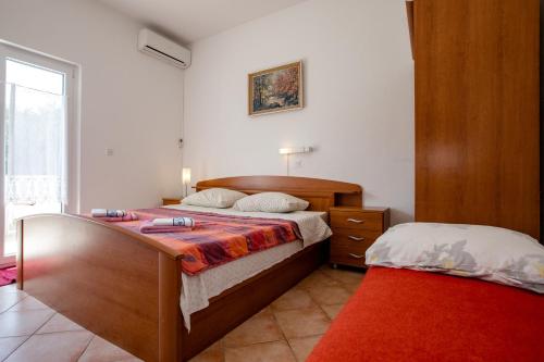 a bedroom with a large bed and a bed sidx sidx sidx at Holiday Home Marjetka in Rab