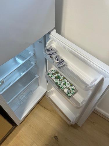 an open refrigerator with some food inside of it at Kettering Service Accomodation 2BRH FreeParking Wifi Smart TV Tea & coffee in Kettering