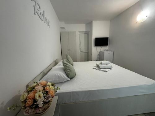 a bedroom with a bed with a bouquet of flowers on it at Vila Yzabelle in Eforie Nord