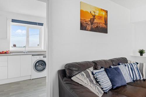 a living room with a couch and a window at JASIG APARTMENTS - Comfy 3 Bedroom house in Nottingham, Sleeps 6 in Nottingham