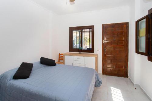 a bedroom with a bed and a window and a door at Perseo in Torrevieja