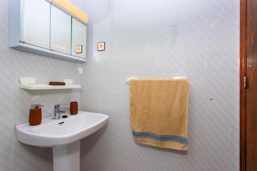 a white bathroom with a sink and a towel at Perseo in Torrevieja