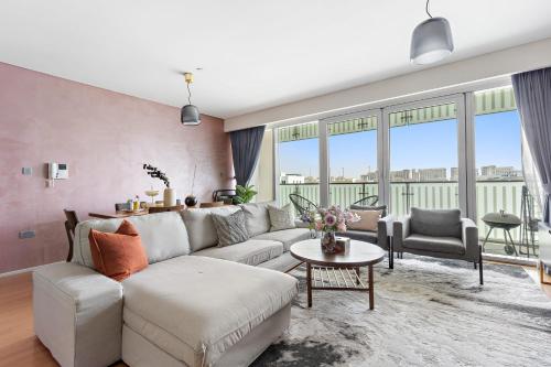 a living room with a couch and a table at Silkhaus Vacation Homes Modern 2BDR Near Banks of Al Rahah in Abu Dhabi