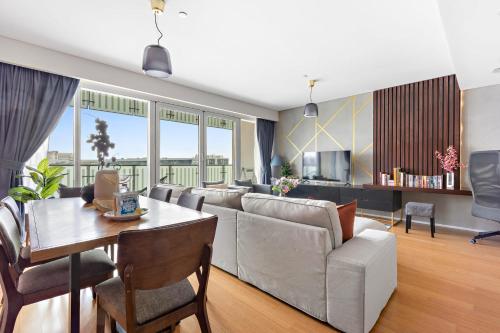 a living room with a couch and a table at Silkhaus Vacation Homes Modern 2BDR Near Banks of Al Rahah in Abu Dhabi