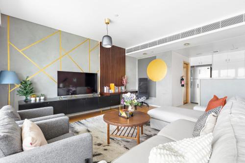a living room with couches and a tv at Silkhaus Vacation Homes Modern 2BDR Near Banks of Al Rahah in Abu Dhabi