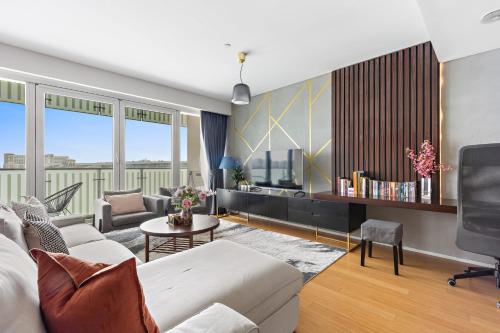 a living room with a couch and a table at Silkhaus Vacation Homes Modern 2BDR Near Banks of Al Rahah in Abu Dhabi