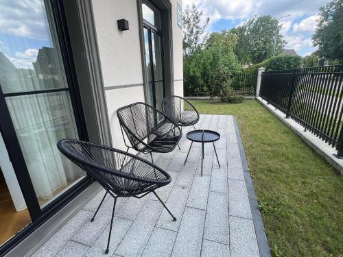 3 sedie nere e un tavolo sul balcone di 2BD,Terrace, AC, next to Dineika Park, Brand NEW, by Cohost a Druskininkai