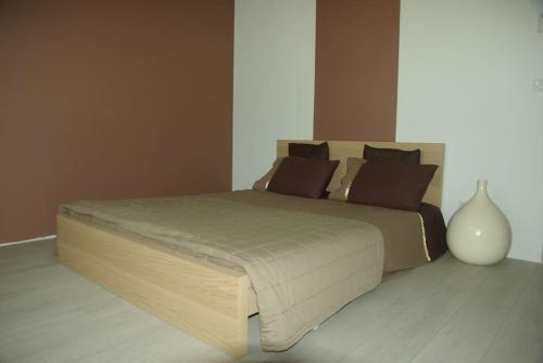 une chambre avec un grand lit avec un vase au sol dans l'établissement Location Lei parpaioun Salernes piscine privée, à Salernes