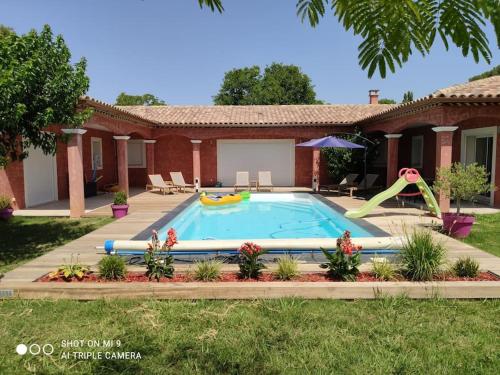 une piscine avec toboggan dans une maison dans l'établissement Location Lei parpaioun Salernes piscine privée, à Salernes