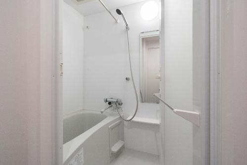 a white bathroom with a tub and a shower at KISETSU Omori II in Tokyo
