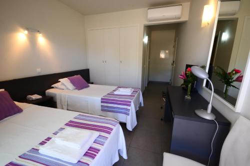 a hotel room with two beds and a table at Boutique & Villas Boliqueime in Boliqueime