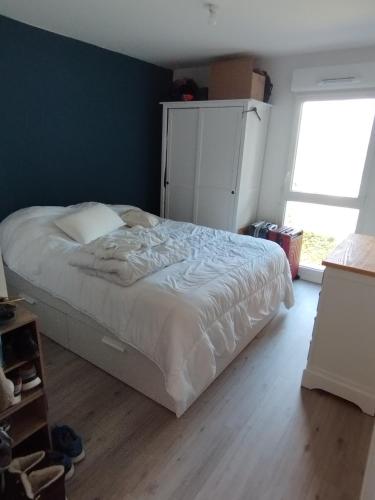 Un dormitorio con una cama y una ventana grande. en Appt cosy 2 pièces proche gare, en Templemars