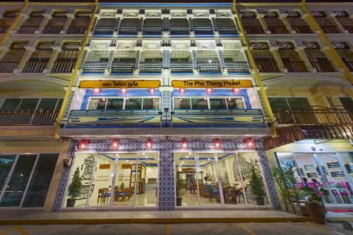 a building with a sign on the front of it at The Pho Thong Phuket in Phuket