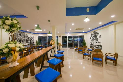 un restaurant avec tabourets bleus, tables et chaises dans l'établissement The Pho Thong Phuket, à Phuket