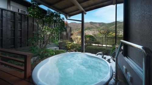 a bath tub on a patio with a view at 御宿瑞鷹 in Atami
