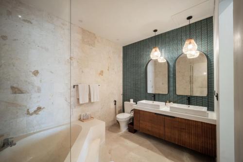 a bathroom with a tub and a sink and a toilet at Villa Artisane in Seminyak