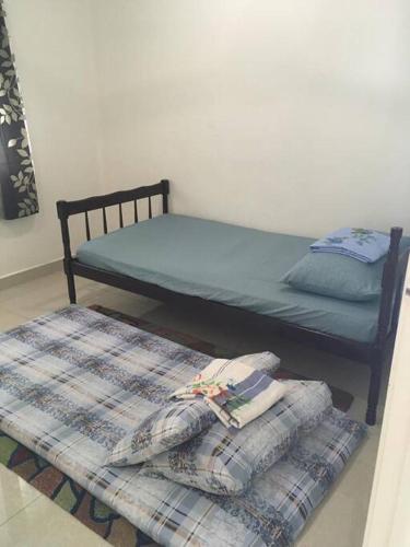 a bed and two pillows in a room at SIREH Cozy Homestay Jln Garuda TelokPanglimaGarang in Teluk Panglima Garang