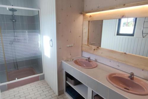 une salle de bain avec deux lavabos, un miroir et une baignoire dans l'établissement Maison 75 m2 piscine chauffée, terrain de tennis, à Prigonrieux