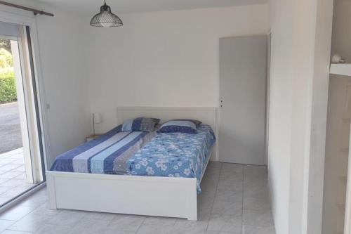 une chambre blanche avec un lit avec une couette bleue dans l'établissement Maison 75 m2 piscine chauffée, terrain de tennis, à Prigonrieux