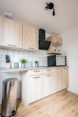 une cuisine avec des placards en bois et une poubelle dans l'établissement Appartement devant Nausicaa, à Boulogne-sur-Mer