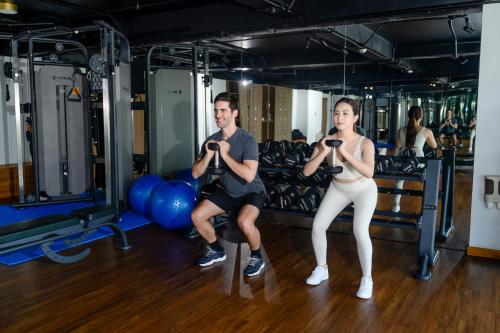 a man and a woman in a gym with weights at Bellerive Hoi An Resort and Spa in Hoi An