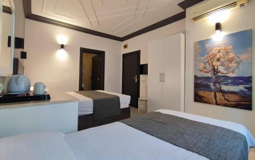 a hotel room with two beds and a painting on the wall at Hotel Peninsula in Istanbul