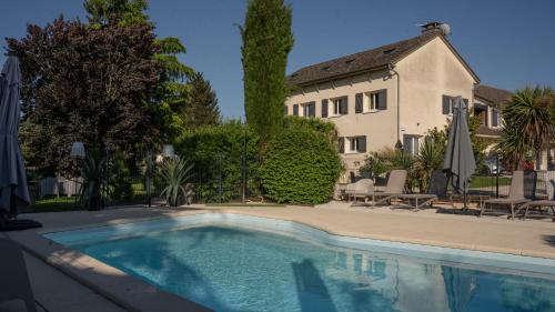 une piscine devant une maison dans l'établissement Hôtel Parc Adélie - Logis Hôtels, à Montagny-lès-Beaune