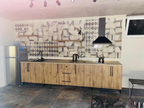 a kitchen with a counter with two sinks and a refrigerator at Sweet Lemon in Batumi