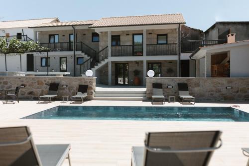 a house with a swimming pool and some chairs at Ahcor Housing - Quinta do Paço in Figueiredo de Alva