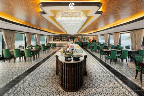 a dining room with tables and green chairs at Catherine Cruises Ha Long Bay in Ha Long