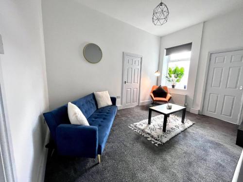 Outdoor Patio, Near Stadium Of Light, Refurbished في Monkwearmouth: غرفة معيشة مع أريكة زرقاء وكرسي