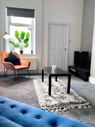 a living room with a blue couch and a table at Outdoor Patio, Near Stadium Of Light, Refurbished in Monkwearmouth