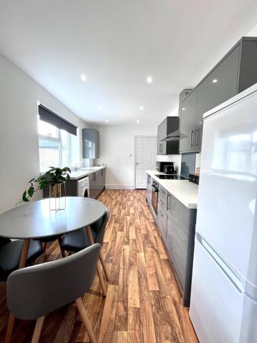 a kitchen with a table and a white refrigerator at Outdoor Patio, Near Stadium Of Light, Refurbished in Monkwearmouth