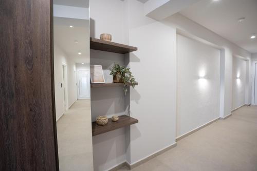 a hallway with white walls and wooden shelves at Sunny Sands Seaview Apartment in Archangelos