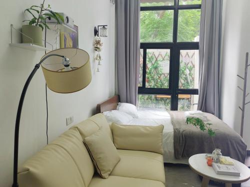 a living room with a couch and a bed at Shanghai Garden Apartment - Near Downtown Wukang Road in Shanghai