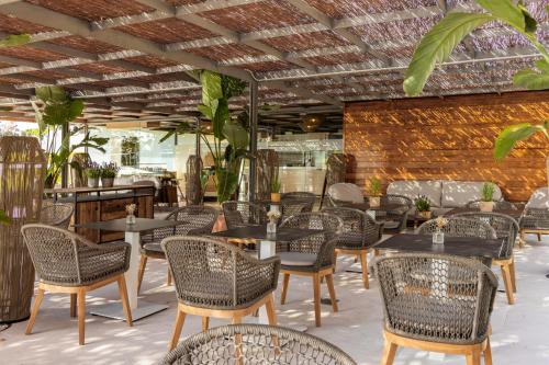 Torre Melina, a Gran Meliá Hotel في برشلونة: مطعم به طاولات وكراسي وجدار من الطوب