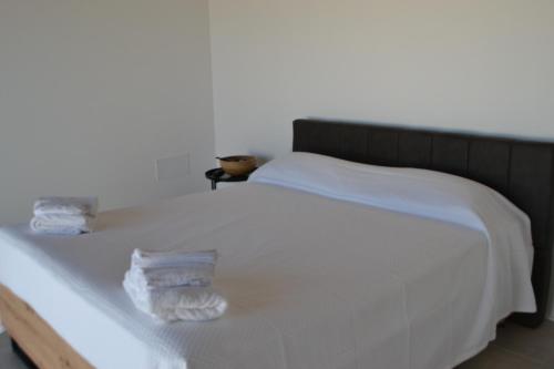 a white bed with two folded towels on it at Tenuta Rapillo in Castellammare del Golfo