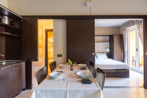 a dining room with a table and a bed at Loano 2 Village in Loano