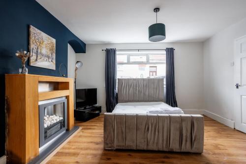 a bedroom with a bed and a fireplace at Enjoy a spacious 3 BR home in Sunderland