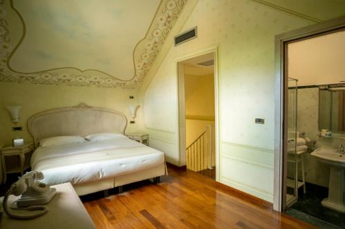 a bedroom with a bed and a bathroom with a sink at Suite Hotel Nettuno in Sestri Levante