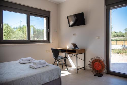 a bedroom with a bed and a desk with a laptop at Villa Nava - Nestled in Olive Trees with Private Pool, by ZanteWize in Alykes