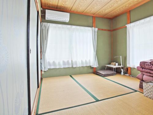 a living room with a window and a fan at ゲストハウス 畔（hotori） in Nishimukai