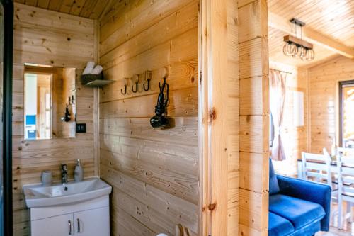 a bathroom in a log cabin with a sink and a blue couch at Morska Cisza in Pleśna